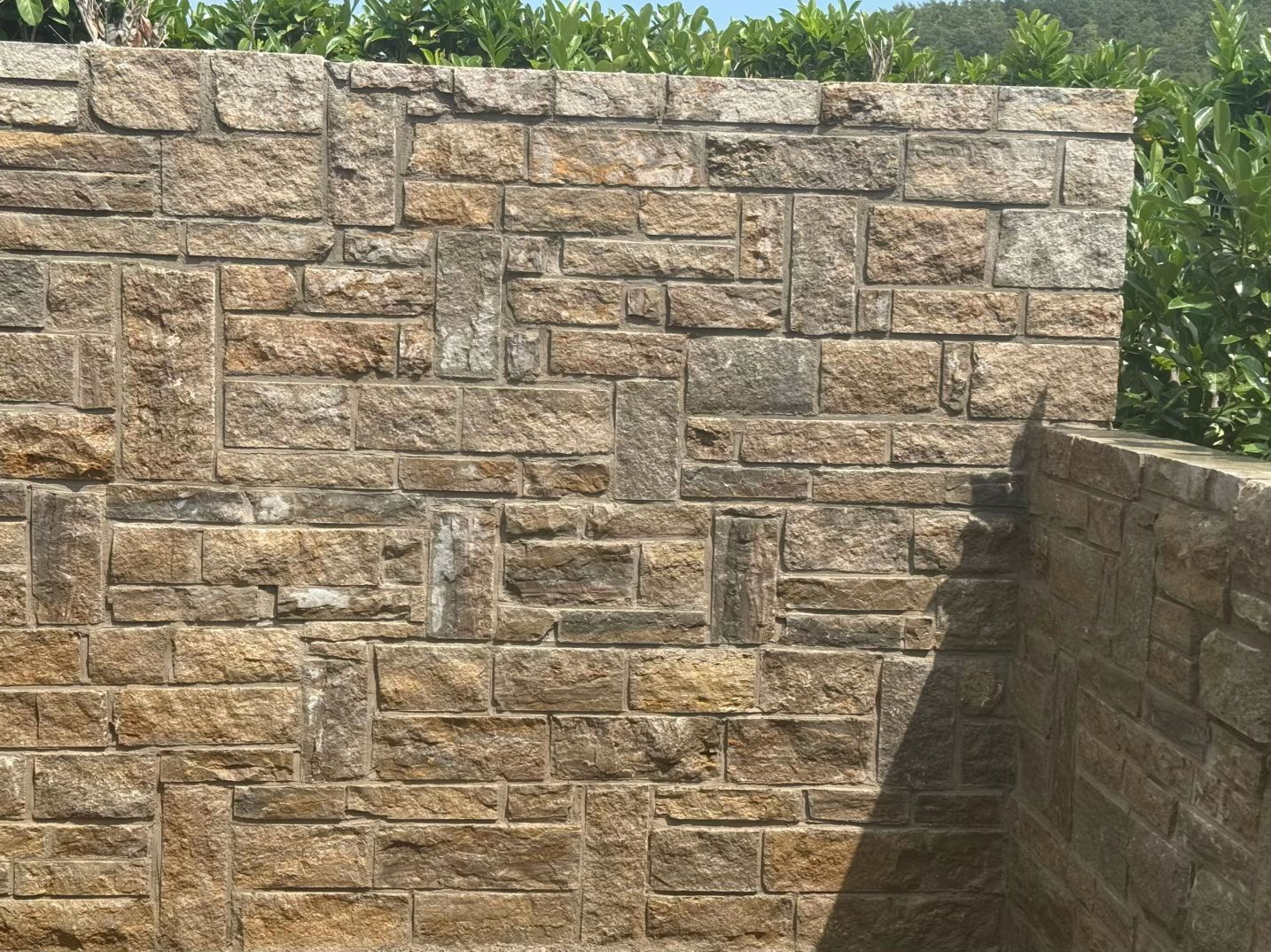 Fertige Natursteinmauer im Garten – Mauerbau von Aron Galabau